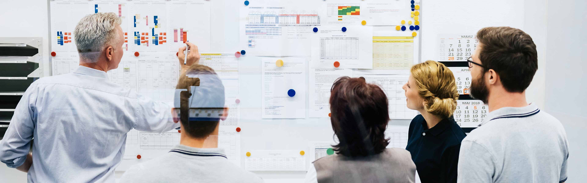 A group of people problem solve using posters and diagrams