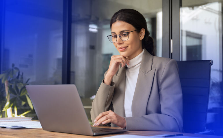 Woman wearing glasses sitting at desk using a computer
