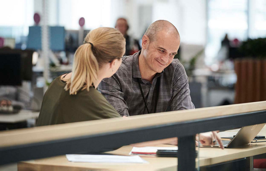A man and a woman sitting next to each other in an office