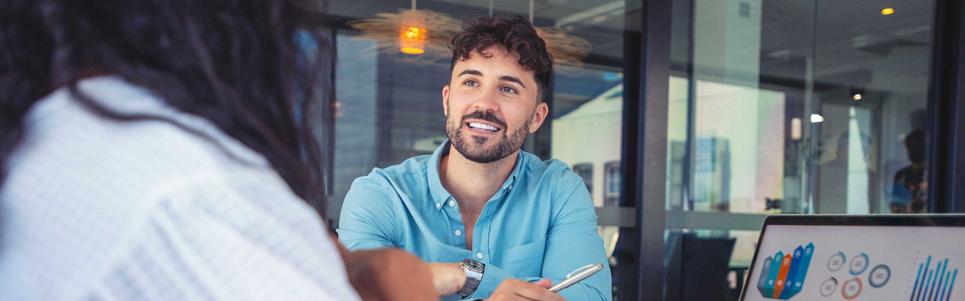 A male CX specialist discussing analytics with a colleague