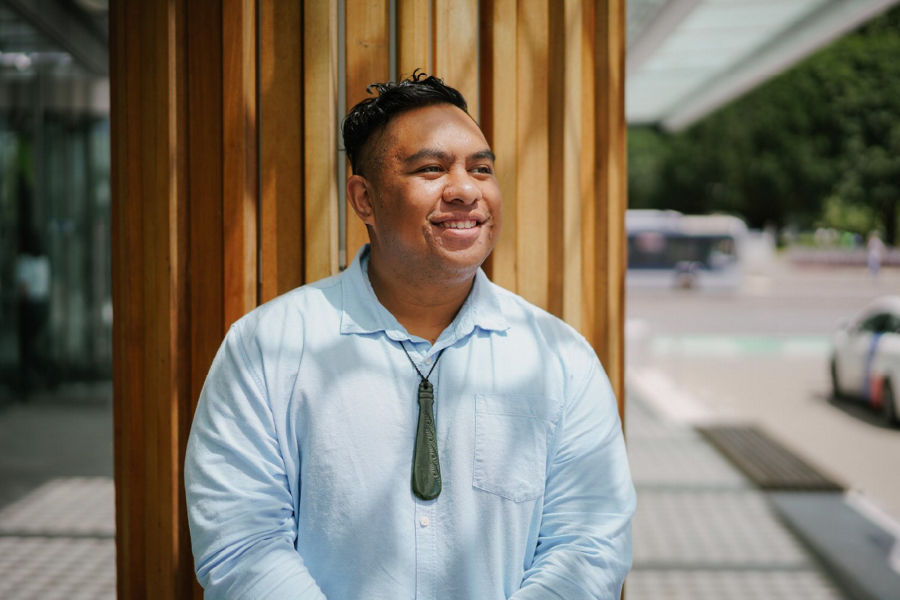 Portrait of Timoti Wharewaka smiling outside looking off camera