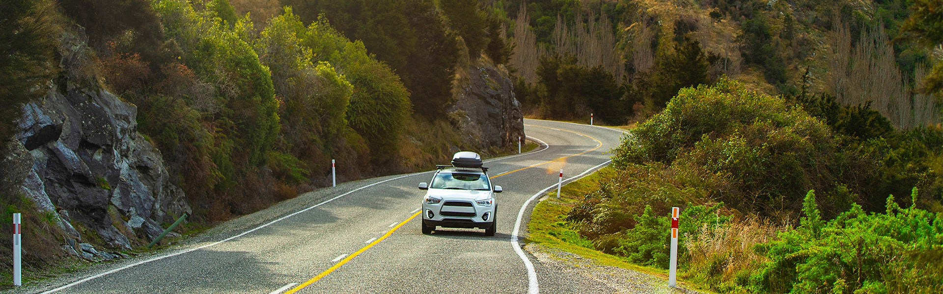 A white car driving on a scenic hilly road