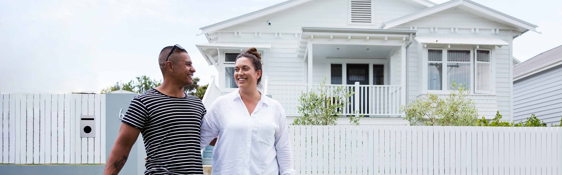 A couple standing outside of a newly purchased house