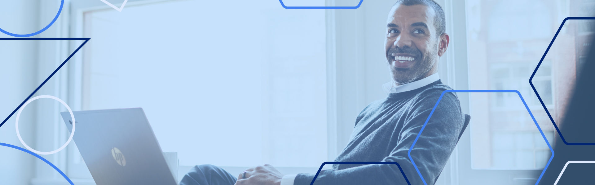 Smiling businessman sitting in a chair using a laptop
