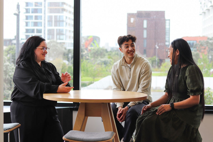 front view of three people sitting at a round table