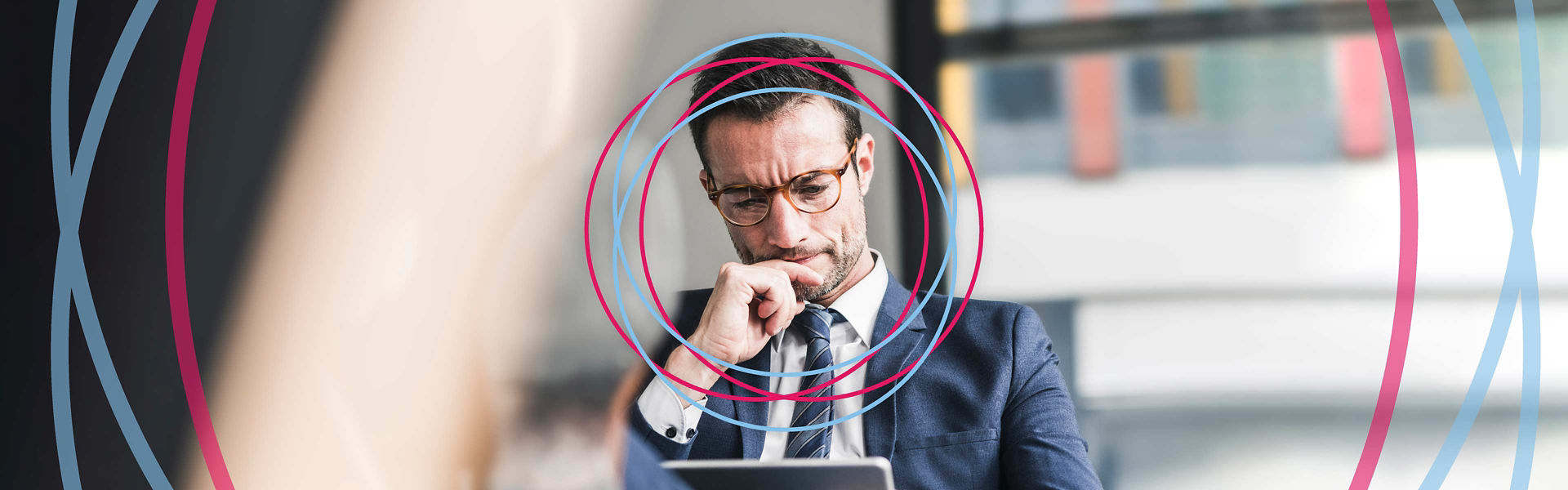 A businessman in deep thought while using a tablet