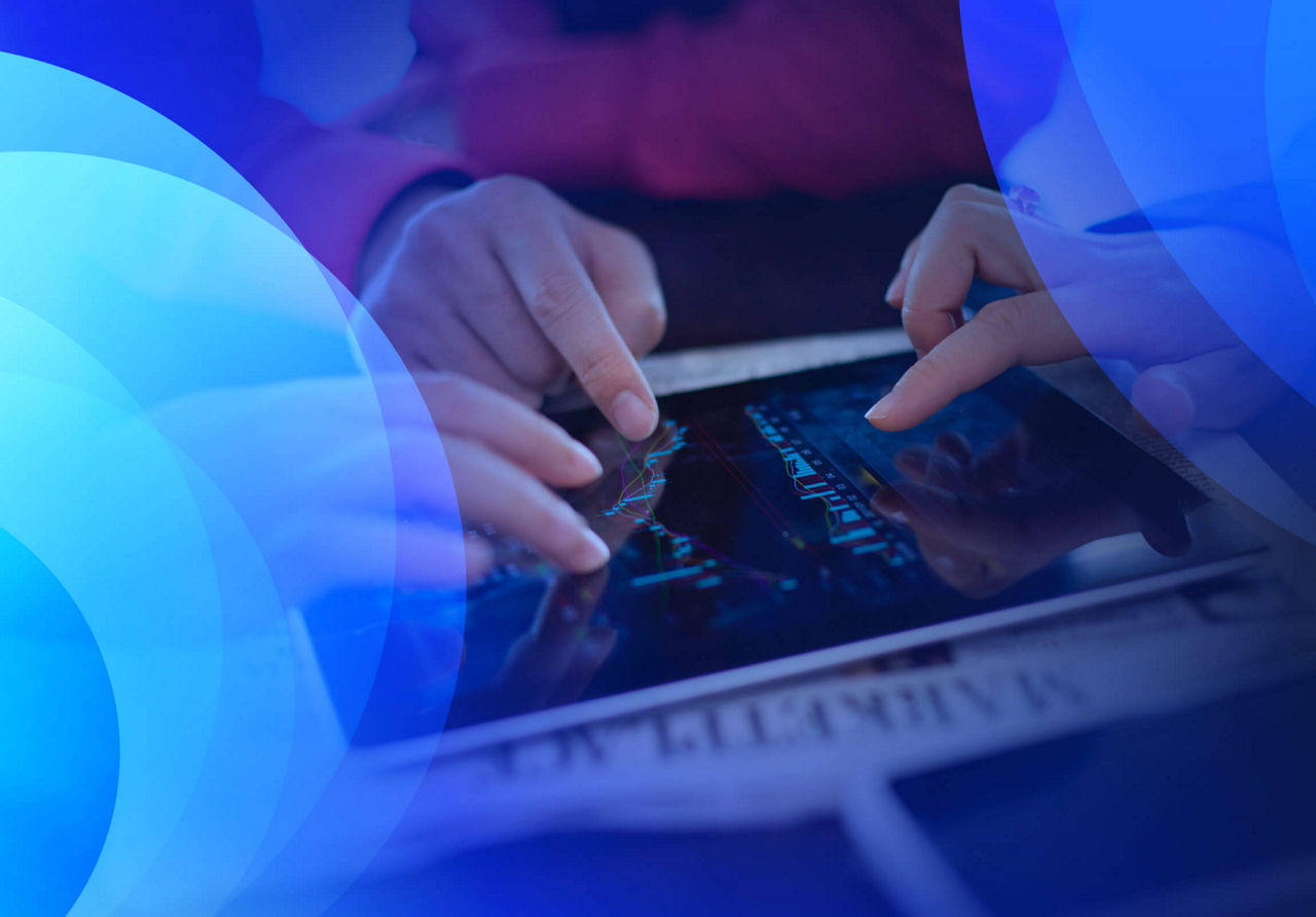Three people interacting with graphs on a tablet