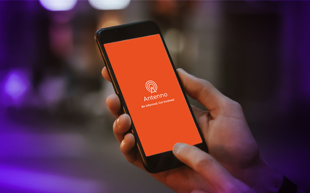 A person holding a mobile phone using the Antenno app