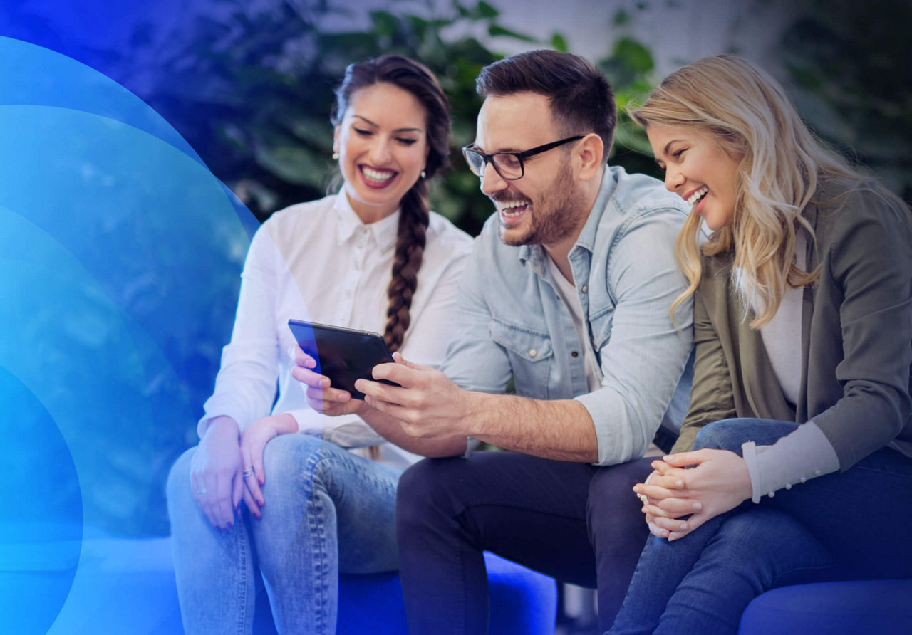 Three people looking at tablet and smiling