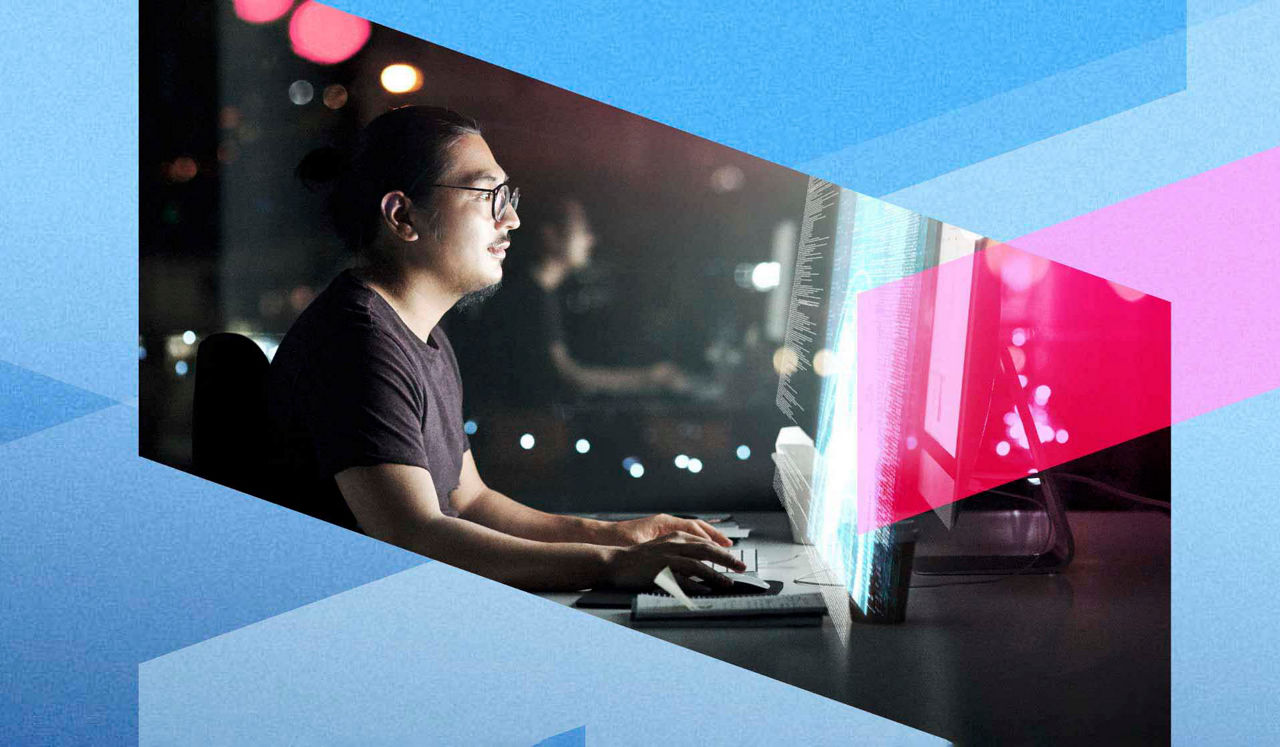 An IT expert using a computer in a city at night