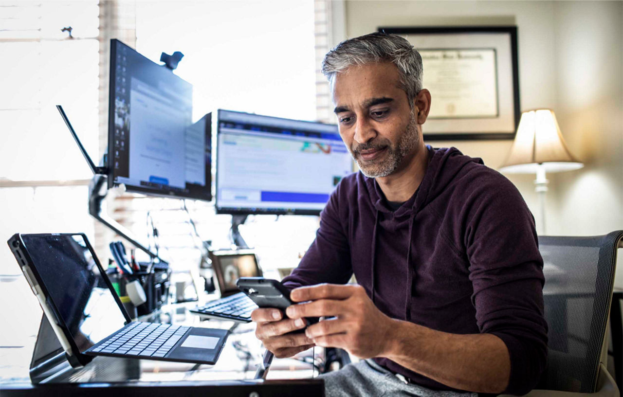 A man working from home checking his mobile phone