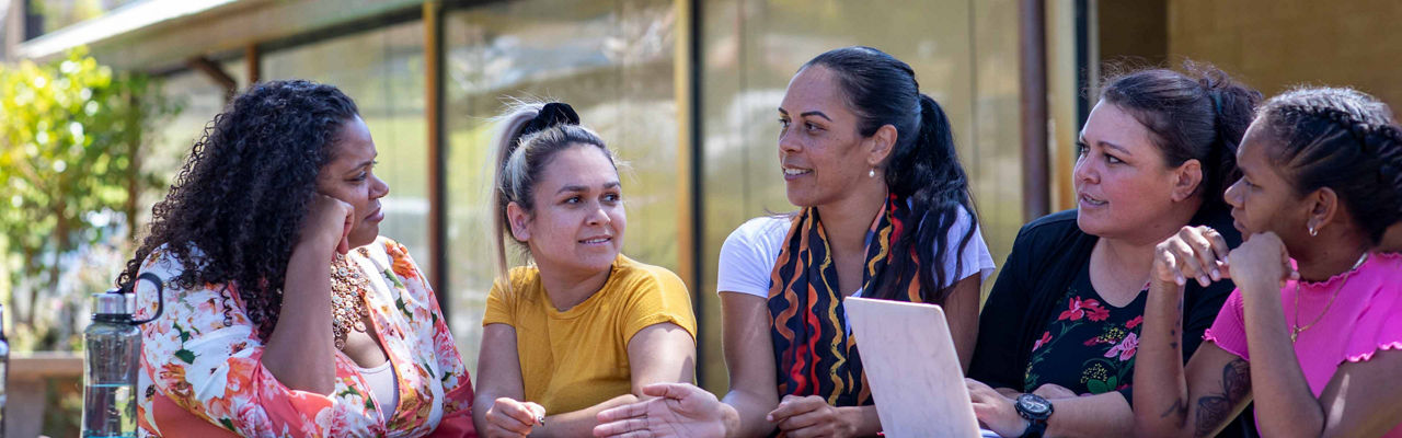 An Aboriginal community project team having a team discussion outside