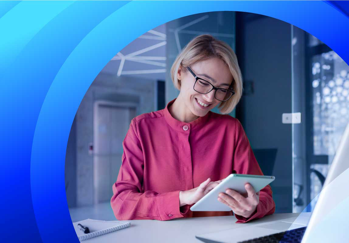 A smiling woman reading articles on a tablet