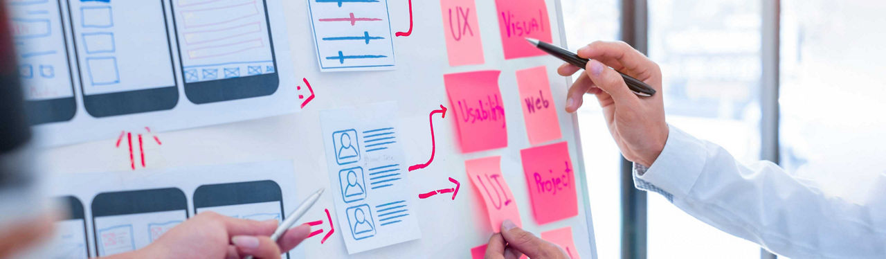 A man writing on pink sticky notes