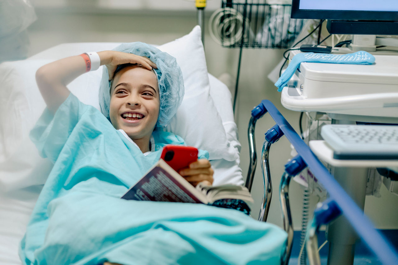 Child in hospital bed smiling