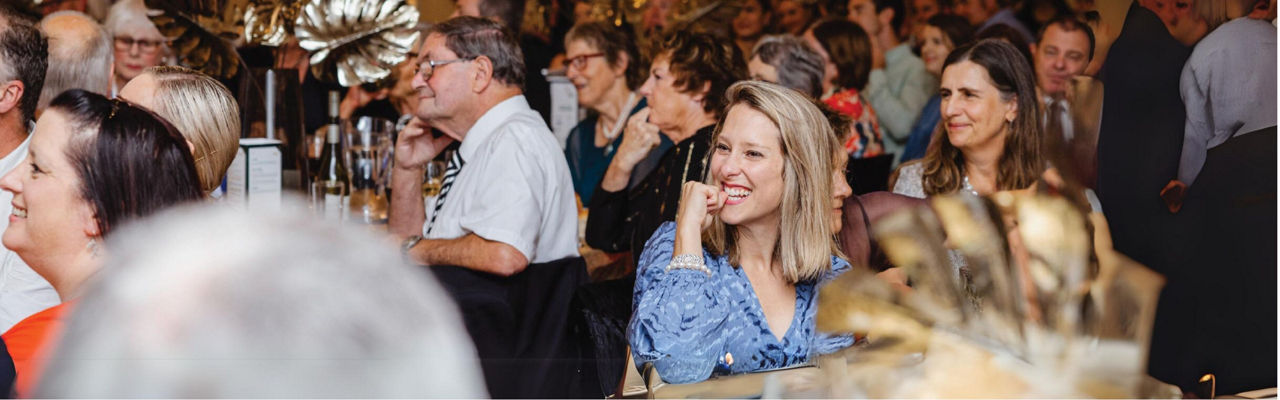 people seated and smiling at an award function