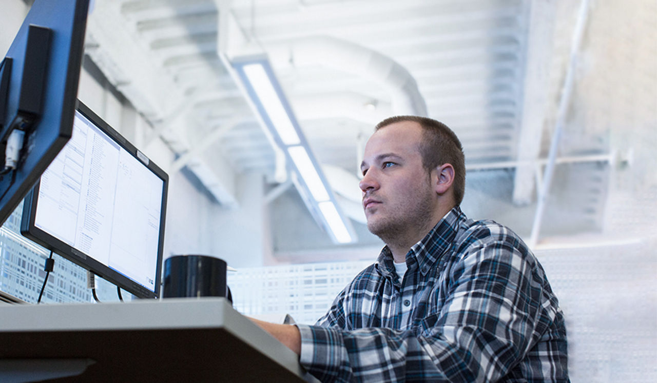 Man in an office looking at computer screens