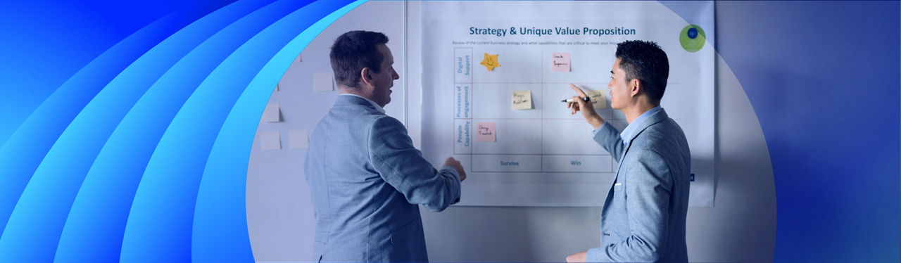 Two businessmen discussing sticky notes on a whiteboard