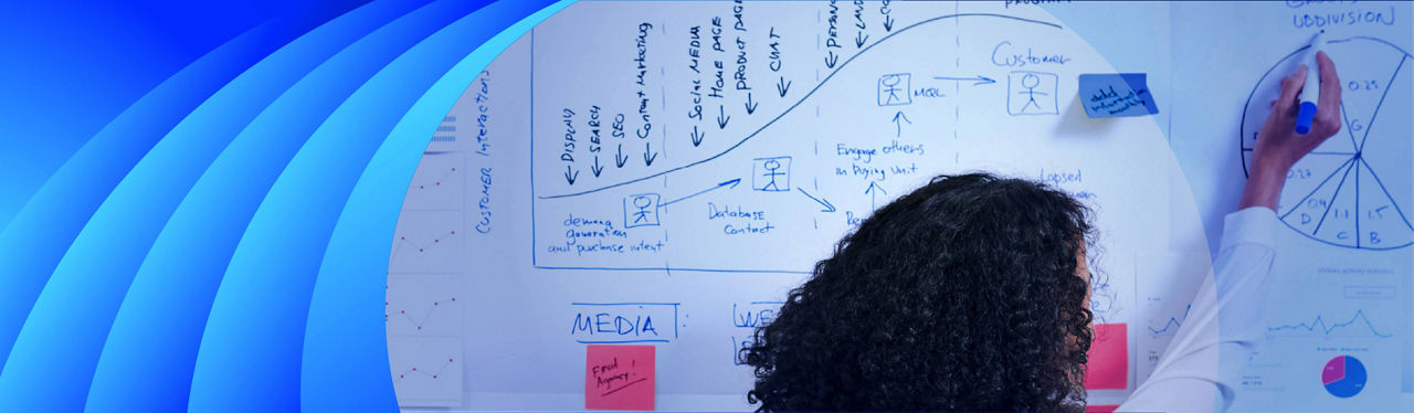 A woman writing up marketing data on a whiteboard