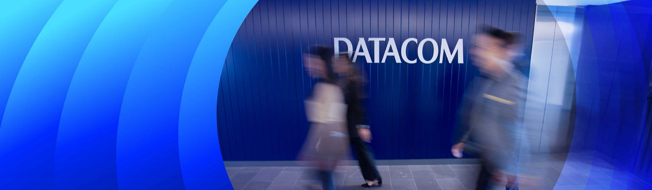 Image of people blurred out what in front of the Datacom sign