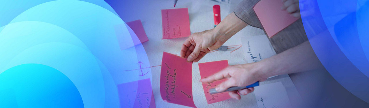 Two people running a process workshop with post-it notes