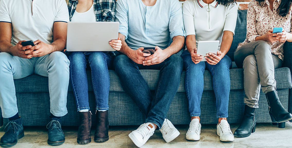 people sitting on couch using devices