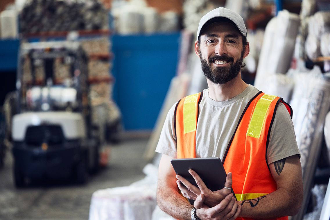 A tradesman smiling holding and ipad