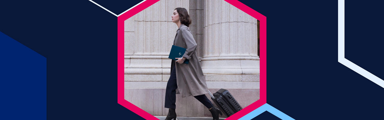 Woman holding an HP laptop while walking down the street with a suitcase