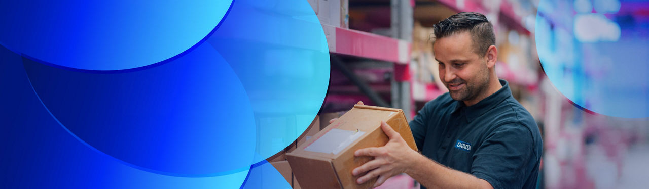 A worker referring to clipboard while on the phone in a warehouse