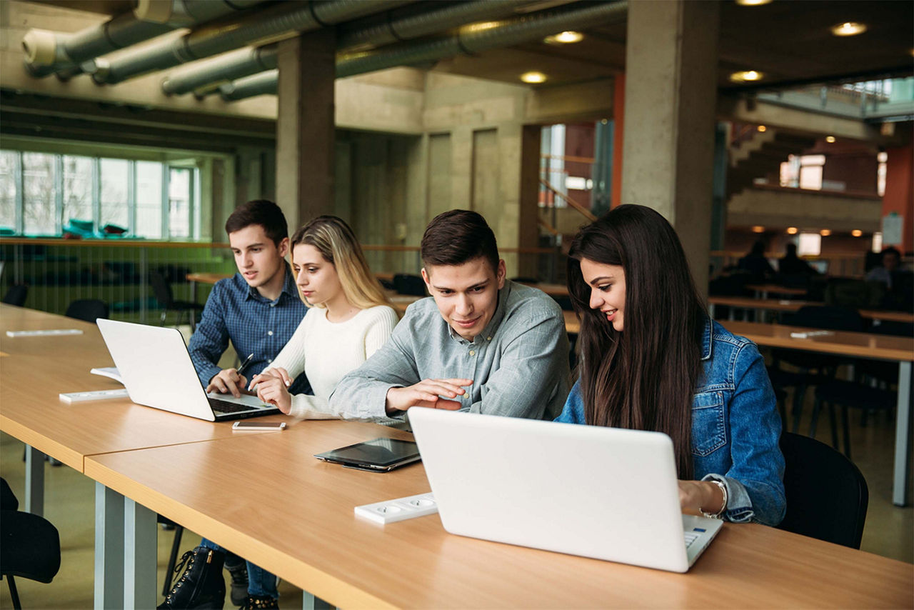 Students in library using computers together