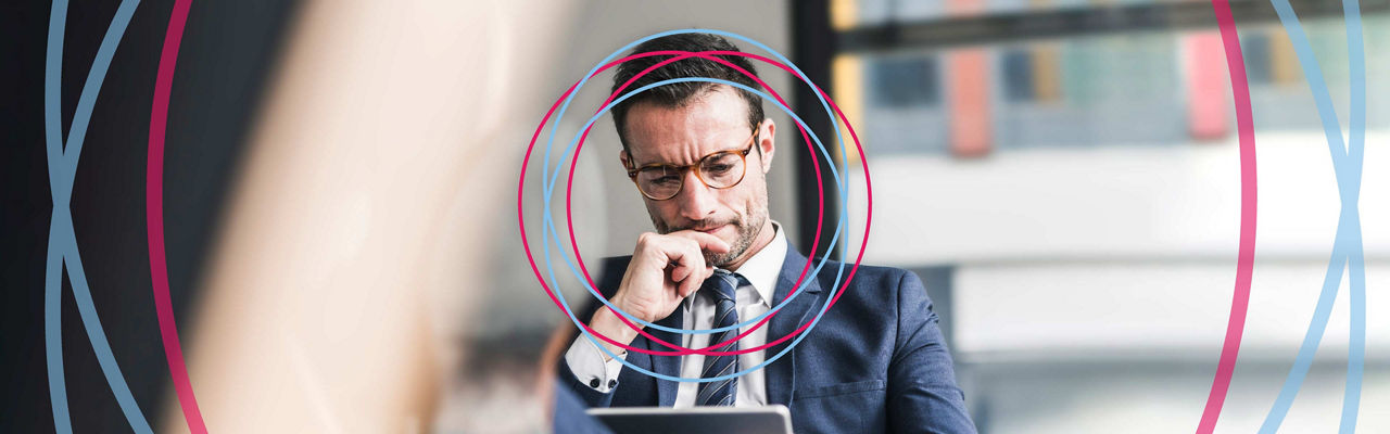 A businessman in deep thought while using a tablet